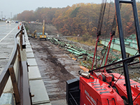 Machine supports wick drain held vertically during installation.